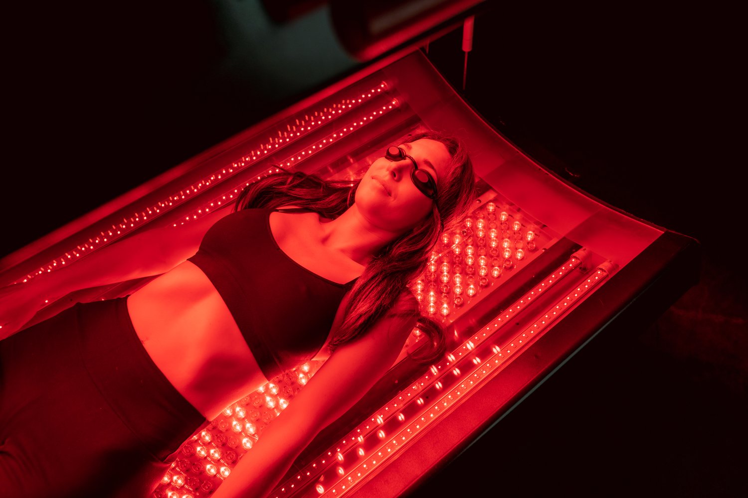 woman in a red light therapy bed